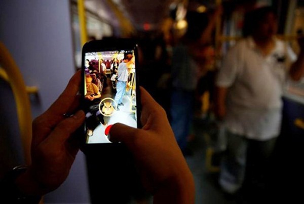Một người chơi Pokemon Go trên xe bus tại Hong Kong (Trung Quốc). Ảnh: Reuters