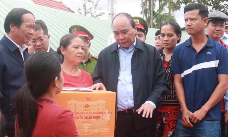 Chủ tịch nước Nguyễn Xuân Phúc thăm và tặng quà động viên người dân vùng ngập lụt sớm vượt qua khó khăn, ổn định cuộc sống.