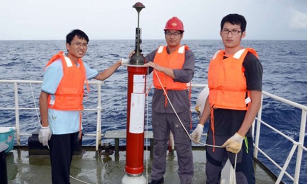 Các nhân viên kỹ thuật Trung Quốc bên cạnh một thiết bị cảm ứng nổi do nước này tự chế tạo. Ảnh: SCMP