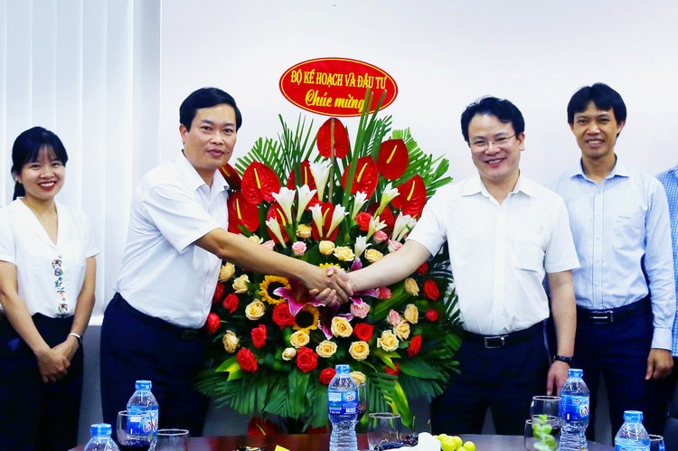 Thứ trưởng Bộ Kế hoạch và Đầu tư Trần Quốc Phương tặng hoa cho đại diện Ban Biên tập Báo Đấu thầu. Ảnh: Lê Tiên