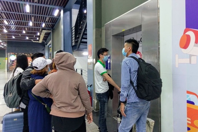 Hành khách chờ đợi trước thang máy trong nhà xe sân bay Tân Sơn Nhất để đón xe công nghệ
