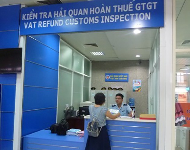 Cán bộ Hải quan sân bay Cam Ranh hướng dẫn hành khách thủ tục hoàn thuế GTGT. Ảnh: Hải Anh