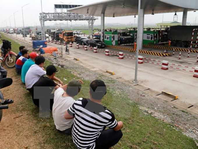 Người dân huyện Tam Nông mang xe ra chặn lối thu phí Trạm thu phí BOT Tam Nông để phản đối. Ảnh TTXVN
