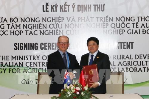 Thứ trưởng Bộ Nông nghiệp và Phát triển Nông thôn Việt Nam Lê Quốc Doanh và Tổng Giám đốc Chương trình Quốc gia ACIAR, tiến sĩ Peter Horne thực hiện nghi thức ký kết hợp tác. Ảnh: TTXVN