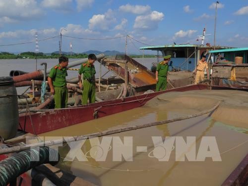 Công an huyện Gia Bình bắt giữ, kiểm tra hai tầu khai thác cát trái phép trên sông Thái Bình. Ảnh: TTXVN
