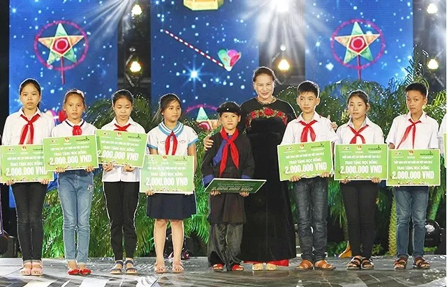 Chủ tịch Quốc hội Nguyễn Thị Kim Ngân trao quà tặng các em nhỏ vượt khó vươn lên - Ảnh: TTXVN
