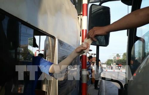 Lái xe sử dụng tiền lẻ mua vé qua trạm BOT tuyến tránh TP Biên Hòa. Ảnh: TTXVN
