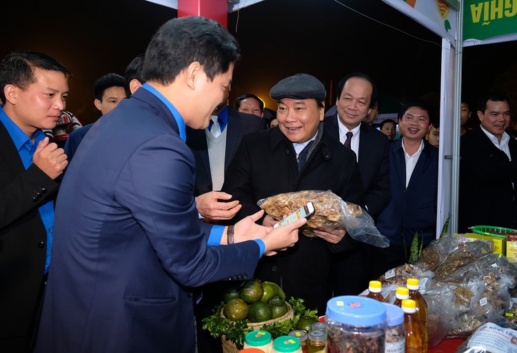 Thủ tướng Nguyễn Xuân Phúc trải nghiệm ứng dụng mua bán nông sản qua điện thoại thông minh do Tỉnh đoàn Hà Giang triển khai. Ảnh: VGP
