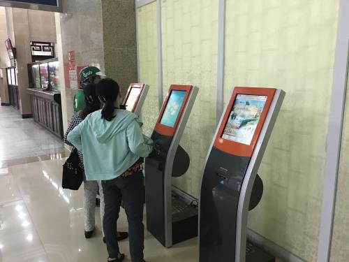 Hành khách mua vé tự động tại cga Hà Nội. Ảnh BNEWS
