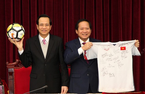 Bộ trưởng Đào Ngọc Dung và Trương Minh Tuấn nhận quả bóng và chiếc áo đấu của U23 từ Thủ tướng Nguyễn Xuân Phúc để chuẩn bị đấu giá. Ảnh: PV