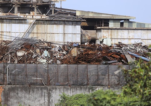 Nhiều tấn phế liệu được đổ sát tường rào của nhà máy thép giáp với khu dân cư ở Hòa Liên. 