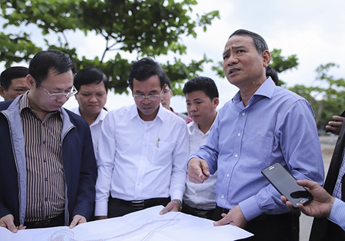 Bí thư Thành ủy Đà Nẵng Trương Quang Nghĩa (bìa phải) xem bản đồ dự án nghỉ dưỡng ở Nam Ô và chỉ đạo tháo gỡ ngay hàng rào chắn sát mép biển.