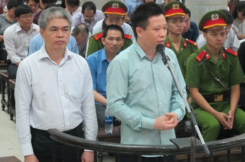Cựu chủ tịch Hà Văn Thắm (áo xanh) và cựu tổng giám đốc Nguyễn Xuân Sơn trước vành móng ngựa. 