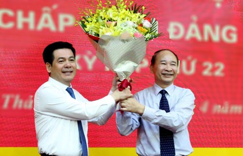 Ông Nguyễn Hồng Diên (trái) nhận hoa chúc mừng từ Bí thư Phạm Văn Sinh (nghỉ hưu từ 1/5).