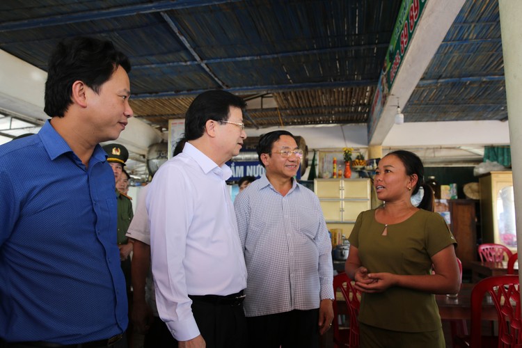 Phó Thủ tướng trò chuyện với chủ cơ sở kinh doanh dịch vụ du lịch tại bãi biển Thiên Cầm. Ảnh: VGP