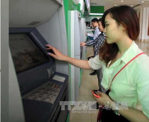 Khách hàng giao dịch tại một điểm ATM tại Hà Nội. Ảnh (tư liệu): TTXVN