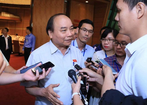 Thủ tướng Nguyễn Xuân Phúc trao đổi với báo chí bên hành lang Quốc hội sáng 7/6. Ảnh: VGP