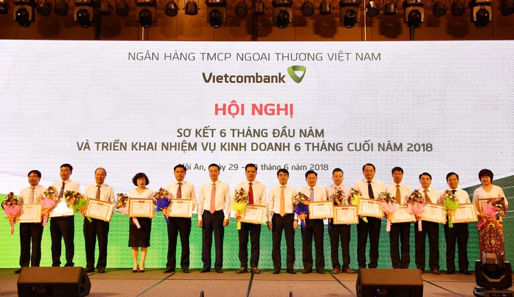 Chủ tịch HĐQT Nghiêm Xuân Thành (thứ 8 từ phải sang) và Tổng giám đốc Phạm Quang Dũng (thứ 6 từ trái sang) tặng Giấy khen và hoa cho 13 chi nhánh tiêu biểu trên một số mặt hoạt động của 6 tháng đầu năm 2018