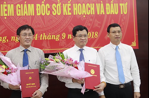 Từ trái qua: Ông Trần Văn Sơn và ông Trần Phước Sơn nhận quyết định và hoa chúc mừng từ Phó chủ tịch Đà Nẵng Hồ Kỳ Minh.