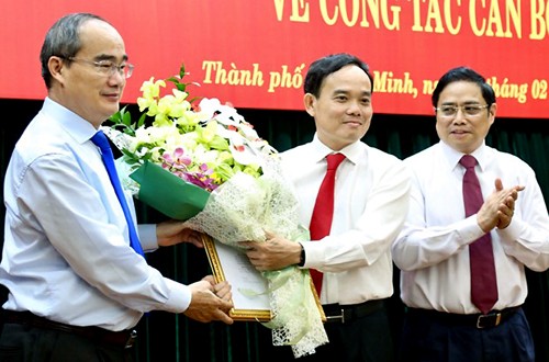 Bí thư Thành ủy Nguyễn Thiện Nhân (trái) tặng hoa cho tân Phó bí thư Trần Lưu Quang.