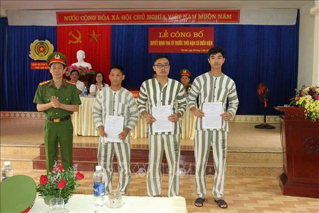 Cựu nhà báo Lê Duy Phong (đứng giữa) nhận quyết định tha tù trước thời hạn có điều kiện - Ảnh: TTXVN