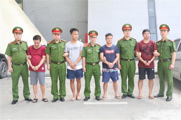Các đối tượng bị truy nã người Trung Quốc được trao trả cho Công an Trung Quốc - Ảnh: TTXVN