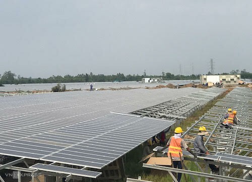 Công nhân lắp những tấm pin điện mặt trời cuối cùng tại một dự án điện mặt trời ở Long An. 