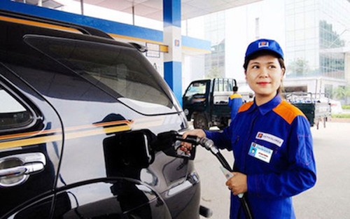 Nhân viên một cửa hàng xăng dầu của Petrolimex bơm nhiên liệu cho xe khách hàng.
