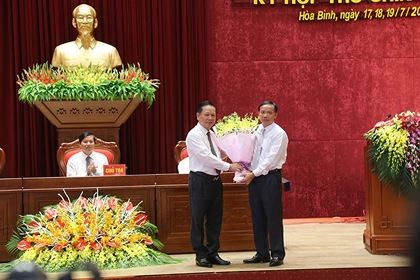 Ông Bùi Văn Tỉnh, Ủy viên BCH Trung ương Đảng, Bí thư Tỉnh ủy Hòa Bình (phải) tặng hoa chúc mừng ông Bùi Văn Khánh được bầu giữ chức Chủ tịch UBND tỉnh.