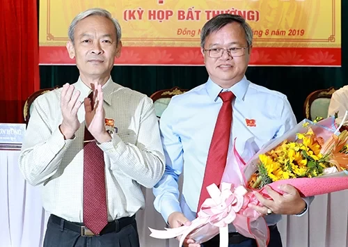 Ông Cao Tiến Dũng (phải) nhận hoa chức mừng từ Bí thư Tỉnh uỷ Đồng Nai Nguyễn Phú Cường