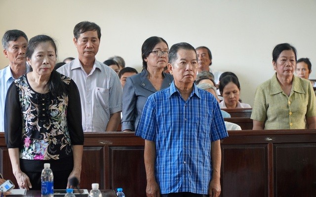 Bị cáo Nguyễn Văn Minh (áo xanh) và các đồng phạm tại phiên xét xử.