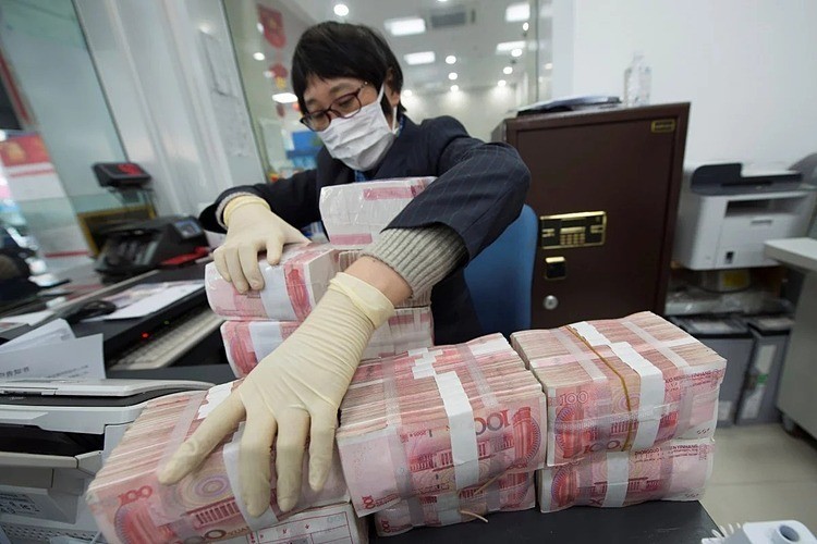 Nhân viên ngân hàng tại Trung Quốc đeo khẩu trang và găng tay khi tiếp xúc với tiền mặt.Ảnh: Reuters