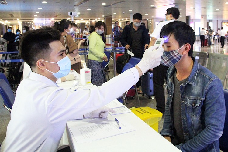 Nhân viên Trung tâm Kiểm dịch quốc tế đo thân nhiệt hành khách tại sân bay Tân Sơn Nhất.