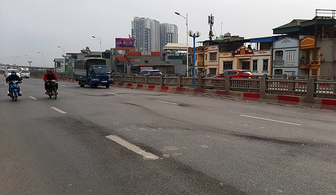 Mặt cầu Vĩnh Tuy đoạn gần đường Minh Khai bị xuống cấp, xuất hiện nhiều vệt lún, ổ gà.