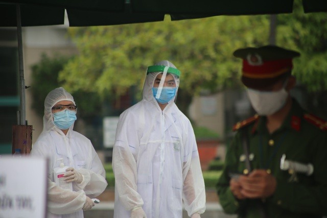 Hình ảnh các nhân viên y tế túc trực tại cổng Bệnh viện Bạch Mai để thực hiện kiểm tra y tế đối với người ra, vào
