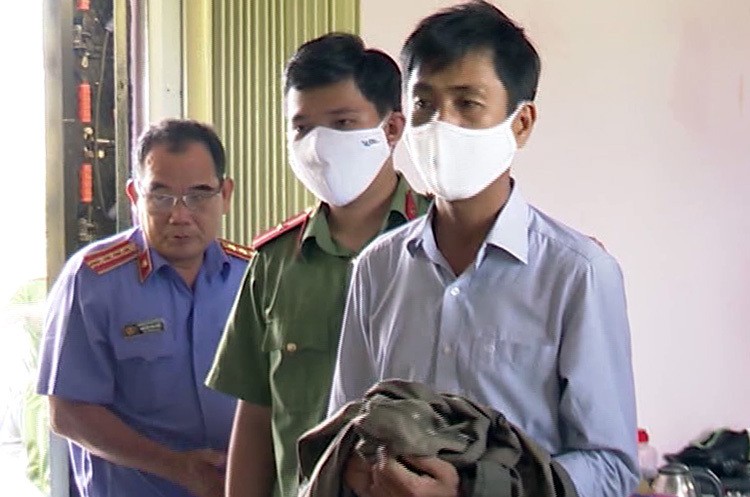 Nguyễn Mộng Xuyên (bìa phải) khi bị bắt tạm giam