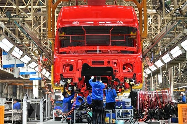 Công nhân làm việc tại dây chuyền sản xuất xe tải hạng nặng của Tập đoàn sản xuất ôtô Thiểm Tây, Trung Quốc ngày 23/4/2020. (Nguồn: THX/TTXVN)