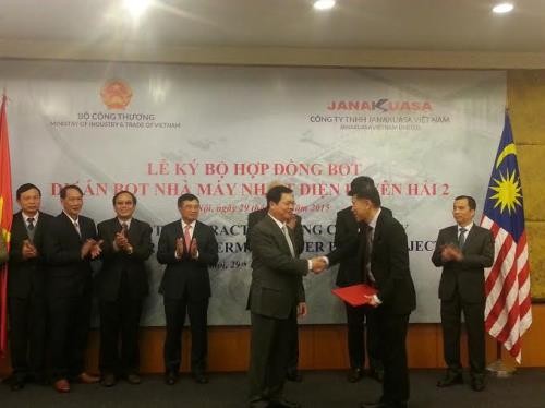 Bộ trưởng Bộ Công Thương Vũ Huy Hoàng trao cam kết bảo lãnh của Chính phủ Việt Nam cho đại diện Công ty Janakuasa. Ảnh: Đức Dũng/BNEWS/TTXVN