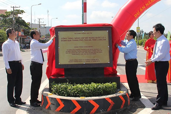 Thứ trưởng Bộ GTVT Lê Đình Thọ (thứ hai từ trái) cùng lãnh đạo địa phương thực hiện nghi thức gắn biển hoàn thành công trình