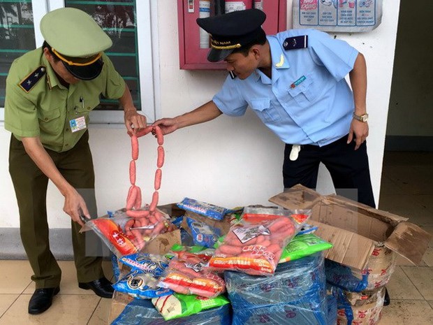 Lực lượng liên ngành thành phố Móng Cái bắt giữ lô hàng thực phẩm nhập lậu không rõ nguồn gốc. (Ảnh: Văn Đức/TTXVN)