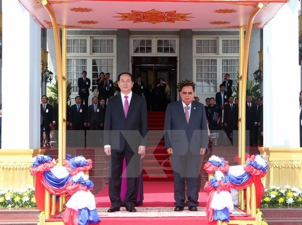 Chủ tịch nước Trần Đại Quang và Tổng Bí thư, Chủ tịch nước Lào Bounnhang Volachith trên bục danh dự. (Ảnh: Nhan Sáng/TTXVN)