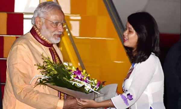 Thủ tướng Ấn Độ Narendra Modi (trái) nhận hoa khi đặt chân tới sân bay Nội Bài. Ảnh: Rediff