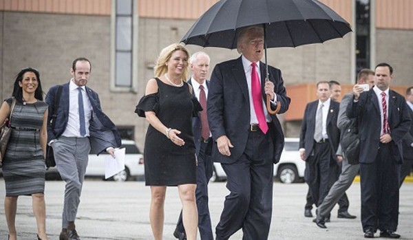 Ông Trump cầm ô che đầu cho mình, mà không che cho bà Bondi bên cạnh. Ảnh:AFP
