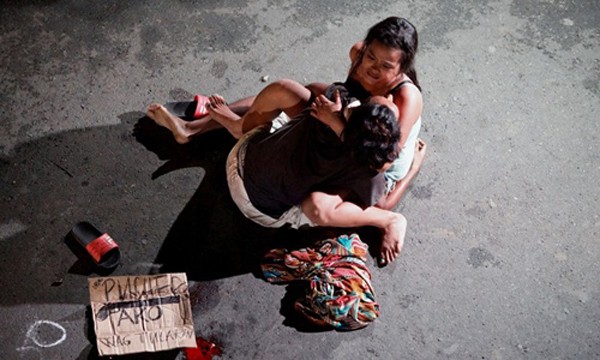 Một phụ nữ ôm chặt xác người chồng bị bắn chết trên đường phố Philippines vì tình nghi buôn bán ma túy. Ảnh:Reuters