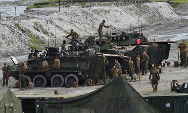 Lính Mỹ bên cạnh các xe thiết giáp hạng nhẹ chuẩn bị tập trận bắn đạn thật với Philippines hôm 10/10. Ảnh: AFP.