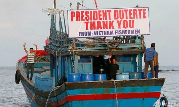 Ngư dân Việt vẫy tay chào tạm biệt Tổng thống Rodrigo Duterte và quan chức Philippines. Ảnh: AFP