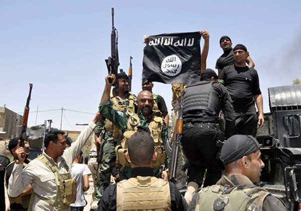 Lực lượng an ninh Iraq gỡ bỏ một lá cờ Nhà nước Hồi giáo tại thị trấn Hit, tỉnh Anbar, hồi tháng 4. Ảnh:Reuters.