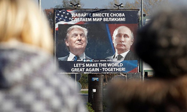 Hai người đi bộ nhìn tấm áp phích có chân dung ông Putin và ông Trump với khẩu hiệu "Hãy cùng khiến thế giới vĩ đại trở lại" tạiDanilovgrad, Montenegro, đông nam châu Âu. Ảnh:Sputnik