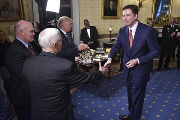Giám đốc FBI James Comey bắt tay phó tổng thống Mike Pencekhi đến gặp Tổng thống Trump ở Nhà Trắng hôm 22/1. Ảnh:Boston Globe