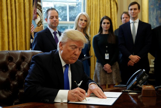 Tổng thống Trump ký sắc lệnh tại Nhà Trắng hôm 24/1 (Ảnh: Reuters)